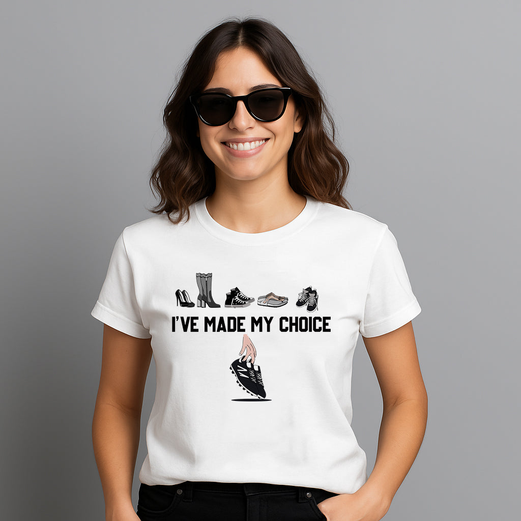Frau mit Sonnenbrille trägt ein weißes T-Shirt mit der Aufschrift „I’ve made my choice“ – darüber verschiedene Frauenschuhe und darunter eine Hand, die ein Paar Fußballschuhe wählt. Das Design steht für Empowerment, Selbstbestimmung und die klare Entscheidung für Frauenfußball. Perfekt für alle, die Mode und Message vereinen wollen. Frauenpower trifft auf Fußballleidenschaft.